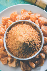 Organic Gur or Jggery Powder is unrefined sugar obtained from concentrated sugarcane juice. served in a bowl. selective focus
