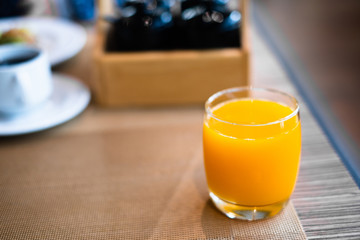 Glass of orange juice on table in restaurant for breakfast.