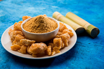 Organic Gur or Jggery Powder is unrefined sugar obtained from concentrated sugarcane juice. served in a bowl. selective focus