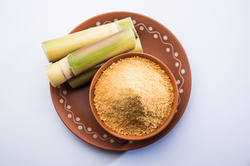 Organic Gur or Jggery Powder is unrefined sugar obtained from concentrated sugarcane juice. served in a bowl. selective focus