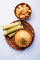 Organic Gur or Jggery Powder is unrefined sugar obtained from concentrated sugarcane juice. served in a bowl. selective focus