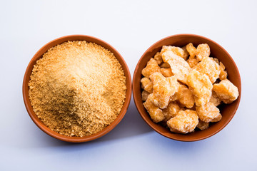 Organic Gur or Jggery Powder is unrefined sugar obtained from concentrated sugarcane juice. served in a bowl. selective focus