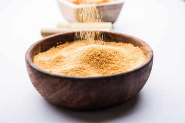 Organic Gur or Jggery Powder is unrefined sugar obtained from concentrated sugarcane juice. served in a bowl. selective focus