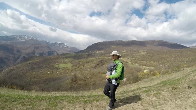 Active family. Father carries his infant son in a baby carrier, hiking in the mountains, Ijevan, Tavush region, Armenia.