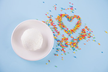 Colorful candies in the shape of a heart and ice cream on the blue background. Place for lettering. Top view, flat lay.