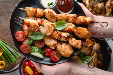 Man holding  kebabs on skewers