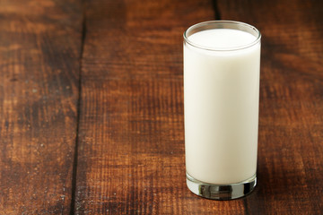 A glass with milk on a wooden rustic table