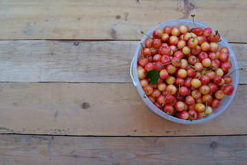 Fresh berries of sweet cherries in a bucket, top view.