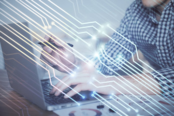 Businessman with computer background with technology theme hologram. Concept of hightech. Multi exposure.