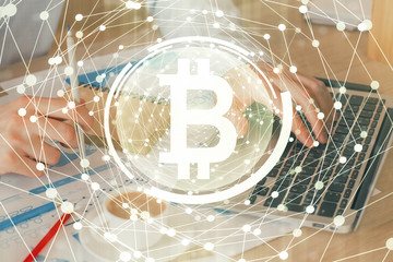 Crypto currency theme hologram with businessman working on computer on background. Concept of blockchain. Double exposure.