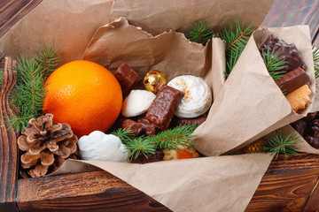 Delicious sweets, chocolates, cookies and oranges for gifts in  wooden box on  vintage table