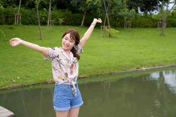 Young beautiful Asian tourist woman relaxing at the park