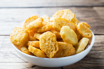 Croutons of white bread baguette with spices in dishes. Wooden background
