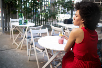 Beautiful happy black woman drinking healthy drink and smiling