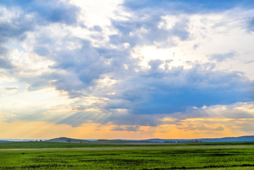 beautiful sunset, evening sun in the field, the rays between the clouds. Beautiful natural landscape
