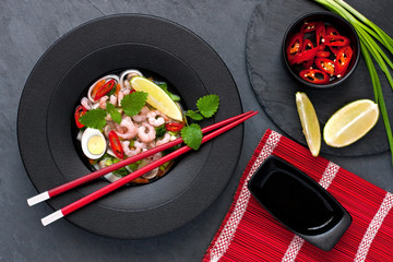 Asian noodle soup  with chopsticks on stone background