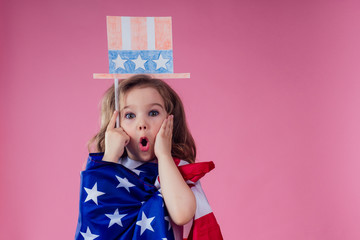 little girl with usa flag paper crown and torch freedom studio pink background