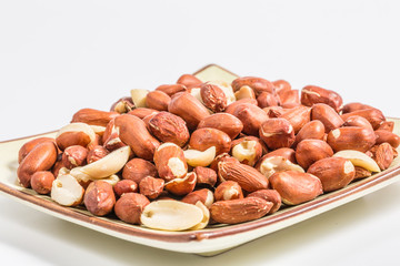 Fototapeta na wymiar Peanut kernels close-up, no shell, peanuts, porcelain plate