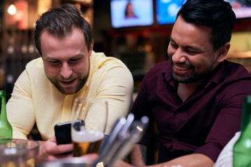 Men using mobile phone at the bar