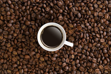 Top view white coffee mug or cup in coffee beans.