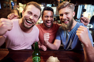 Portrait of three screaming men in the pub