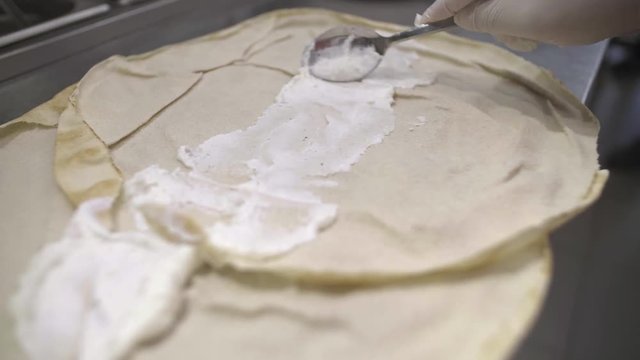 Chef prepares fried chicken sadwich, putting garlic