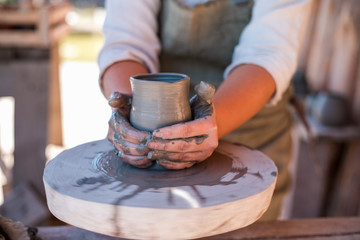 Fototapeta na wymiar Potter is creating earthenware on potter's wheel.