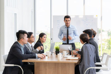 Businesspeople discussing together in conference room during meeting at office.