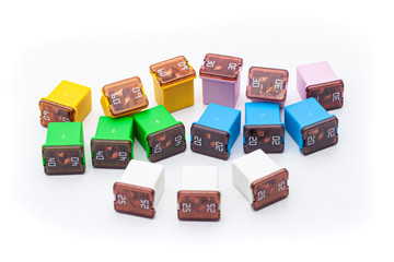 Blade low profile fuses with different ampers on isolated white backgrounds. Electric car parts.