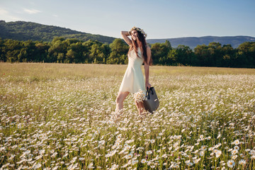 Beautiful girl in daisy field. Summer sunset