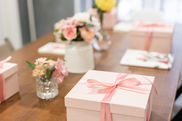 Gift box tied with ribbon on wooden table. Lifestyle. Education in the school of floristry. Master class on making bouquets. Summer bouquet.