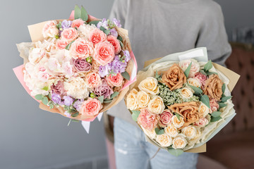 Two Small Beautiful bouquets of mixed flowers in woman hand. Floral shop concept . Beautiful fresh cut bouquet. Flowers delivery