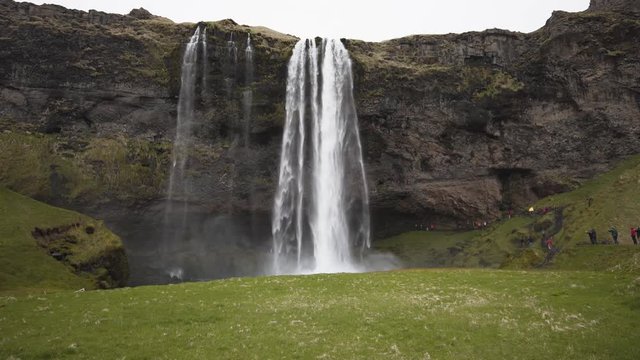 Front view of the majestic waterfall Seljalandsfoss located in Iceland. Massive amount of tourists all taking the same pictures