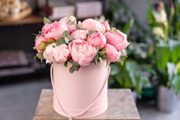 Pink peonies on the old grey table. Beautiful peony flower for catalog or online store. Floral shop...