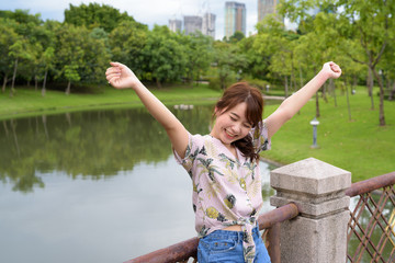 Young beautiful Asian tourist woman relaxing at the park