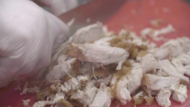 Chef cuts fried chicken breast to preapre a sandwich, close up