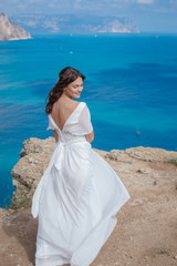 A beautiful bride standing on the coast. The bride in mountains. Wedding