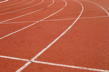 Fototapeta premium all-weather running track, rubberized artificial racing lane surface for track and field athletics, texture of white lines and curved in the stadium