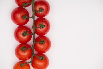 Cherry tomatoes on branch isolated on white background. Top view.