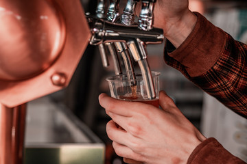 Artisan beer company serving free drinks during music festival. Macro shot of hands and levers. 