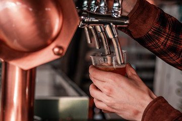 Artisan beer company serving free drinks during music festival. Macro shot of hands and levers. 