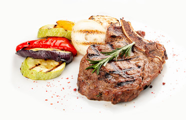 Veal bone steak with grilled vegetables on a white background