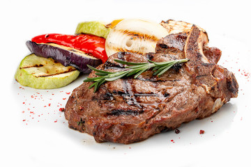 Veal bone steak with grilled vegetables on a white background