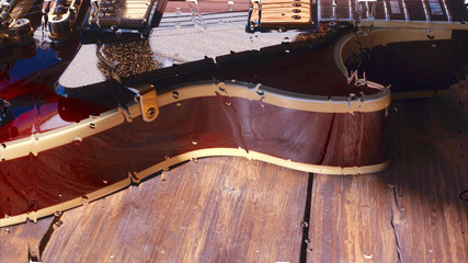 electric guitar behind the glass with water drops . closeup