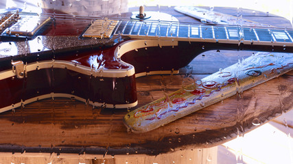 electric guitar behind the glass with water drops . closeup