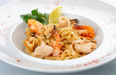 Tagliatelle with seafood. Italian traditional dish. On a white background