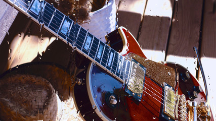 electric guitar behind the glass with water drops . closeup