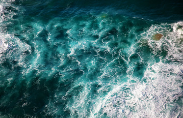 Sea water with foam waves, shot from above abstract natural background and texture