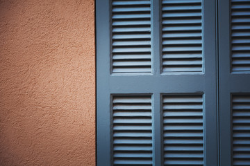beige wall and blue shutters closeup, abstract background and texture
