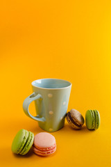  a cup of tea and macaron arranged in a beautiful composition on a yellow background